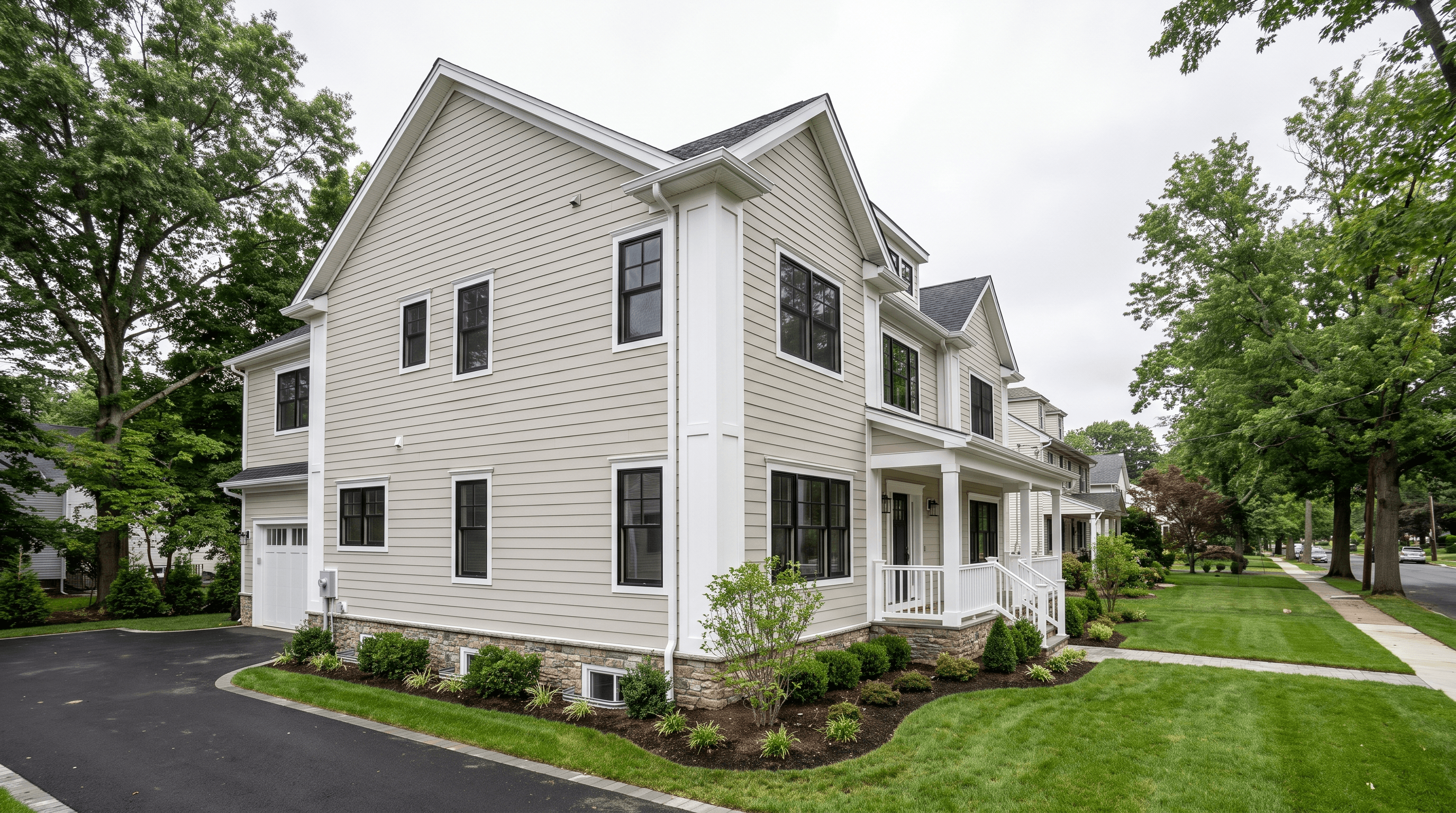 Suburban New Jersey home newly clad in light greige fiber cement lap siding with crisp white trim